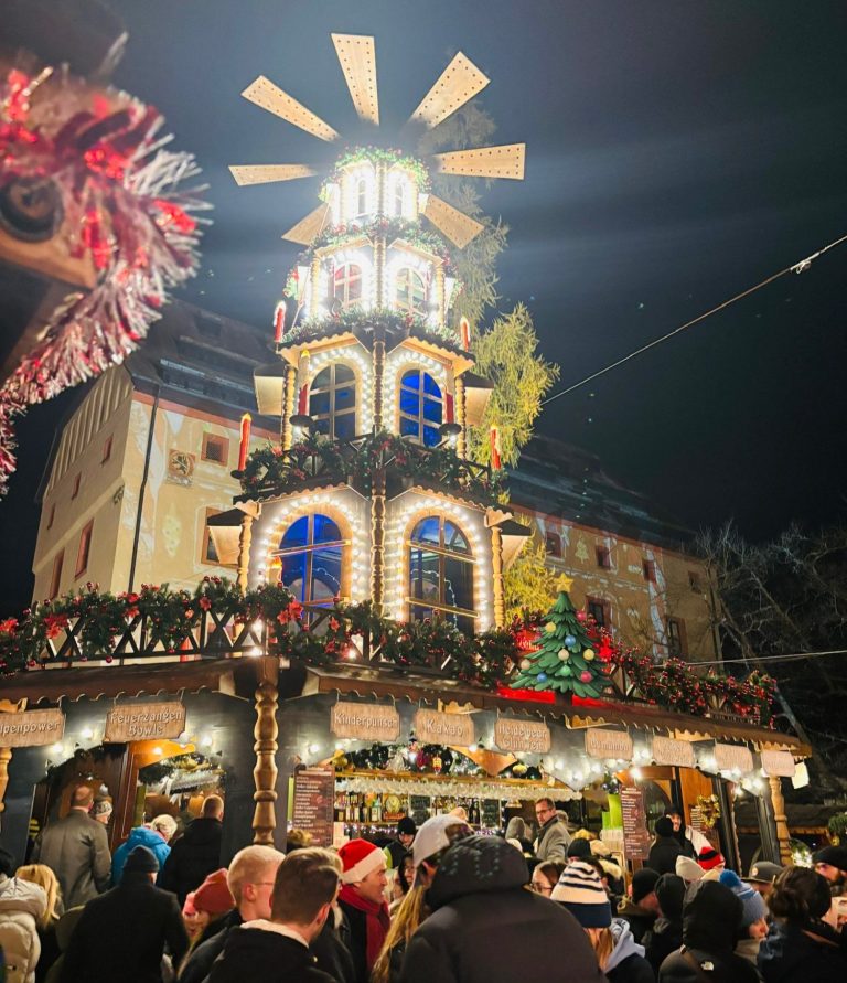 Große, beleuchtete Weihnachtspyramide mit Holzfassade und Krippe in der Altstadt
