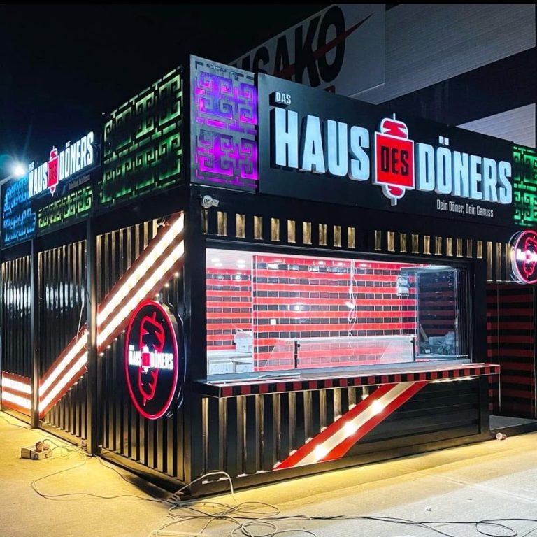 Gastronomiecontainer mit LED-Fassade bei Nacht – Haus des Döners mit Glas-Front, rotem Fliesendesign und Verkaufsmodul